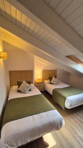 two beds sitting in a room with at Apartamentos Playa de Camariñas in Camariñas
