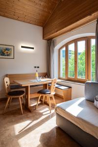 a room with a table and chairs and a bed at Baumgartnerhof in Lagundo