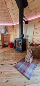 a living room with a stove in a log cabin at Tone valley view glamping in Wellington
