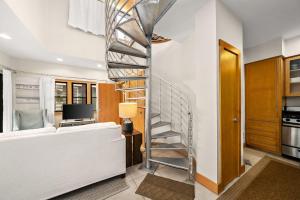a spiral staircase in a living room with a couch at Brighton Carriage House in Rosemary Beach