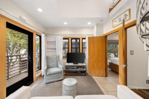 a living room with a television and a balcony at Brighton Carriage House in Rosemary Beach +37 photos