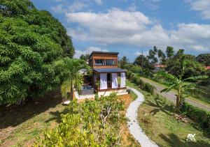 a small house on a hill with a gravel road at Bungalow en duplex avec Jacuzzi in Sainte-Rose
