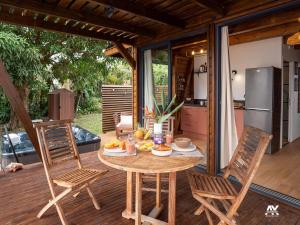 a table and chairs on a deck with a kitchen at Bungalow en duplex avec Jacuzzi in Sainte-Rose