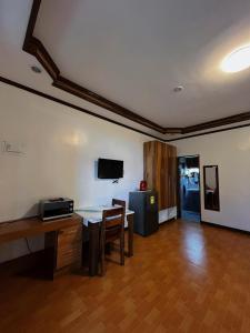 a living room with a table and a desk and a television at Takbo Beach Resort in General Luna
