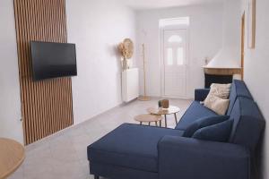 a living room with a blue couch and a tv at LD Home in Lixouri