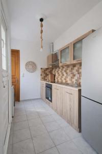 a kitchen with wooden cabinets and a white refrigerator at LD Home in Lixouri