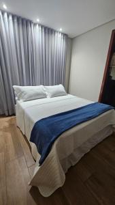 a bedroom with a large bed with a blue blanket on it at Casa Violeta in Ouro Preto