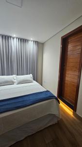 a bedroom with a large bed with a window at Casa Violeta in Ouro Preto