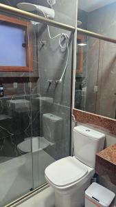 a bathroom with a toilet and a glass shower at Casa Violeta in Ouro Preto