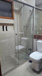 a bathroom with a glass shower with a toilet at Casa Violeta in Ouro Preto