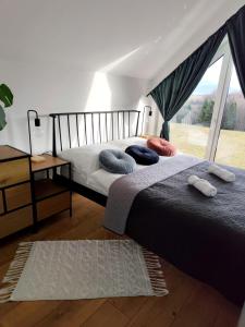 a bedroom with two beds with pillows and a window at Górska Stodoła - Domek z Prywatnym Jacuzzi in Lipowa
