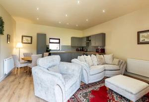 a living room with two couches and a kitchen at Beech Tree Park Cottages in Hatfield