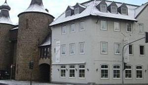 a large white house with a brick building at Hotel am Hexenturm in Jülich