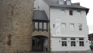a large white building with an archway in front of it at Hotel am Hexenturm in Jülich +1 photo