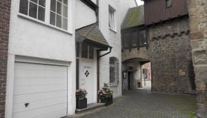 an alley with a white building with a garage at Hotel am Hexenturm in Jülich
