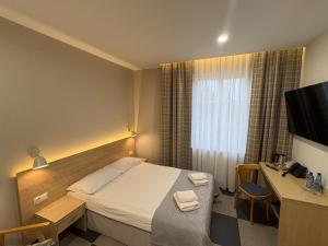 a hotel room with a bed and a desk and a television at Eco Nieborów in Nieborów
