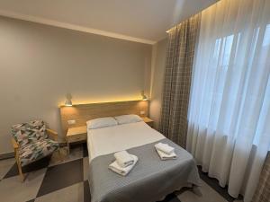 a bedroom with a bed and a chair with towels on it at Eco Nieborów in Nieborów +178 photos