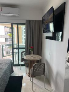 a bedroom with a table and a tv on a wall at Flat Costa Mar in Recife +120 photos