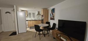 a living room with a television and a table and chairs at La Source in Villers-le-Lac