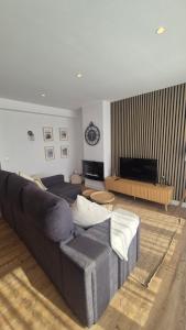 a living room with a couch and a television at Apartamentos Playa de Camariñas in Camariñas