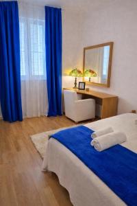 a bedroom with a bed and a desk with a mirror at Apartman David in Postira