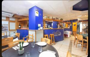 a restaurant with tables and chairs and a blue counter at Hostal Andrés in El Saler