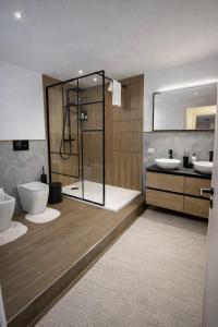 a bathroom with a shower and two sinks and a toilet at CASA NO-MA in centro storico in Marsala +26 photos