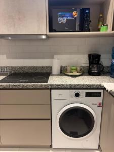 a kitchen with a washing machine and a microwave at Modern Studio with Balcony in Asunción