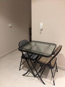 a glass table and two chairs in a room at Modern Studio with Balcony in Asunción