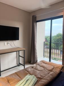 a bedroom with a bed and a large window at Modern Studio with Balcony in Asunción