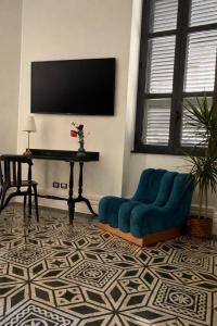 a living room with a blue couch and a piano at Dimora di Duen - Villa Storica di Charme in Villa San Giovanni