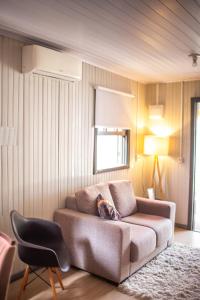 a living room with a couch and a chair at Chalé 10 min do centro in Gramado +1 photo