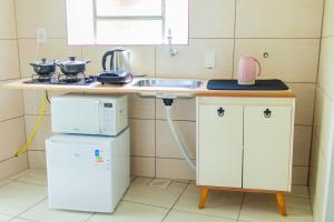 a small kitchen with a sink and a microwave at Chalé 10 min do centro in Gramado