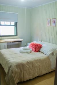 a bedroom with a large bed with towels on it at Chalé 10 min do centro in Gramado