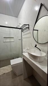 a white bathroom with a sink and a mirror at Hotel Luz in Fronteira