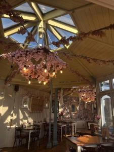 a dining room with tables and flowers hanging from the ceiling at The Cartologist in Durham