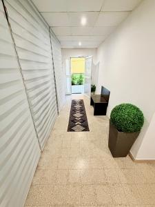an empty hallway in an office with a plant at MBS Marconi Bridge Suites Guest House in Rome