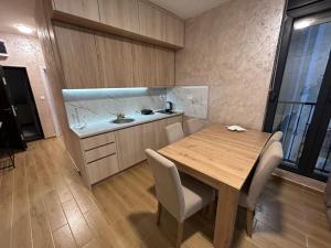 a small kitchen with a wooden table and chairs at Apartman Điki in Đenovići