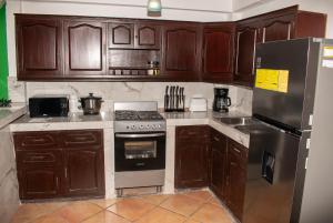 a kitchen with wooden cabinets and a stove and refrigerator at Casa Verde in Granada