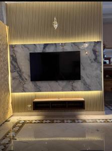 a large television on a wall with a marble counter at super nova 1 in Lahore