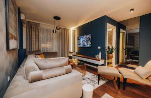 a living room with a white couch and blue walls at Impresia apartments in Kragujevac