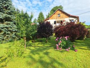 a house with trees and flowers in a yard at Apartmán Renata in Rudník