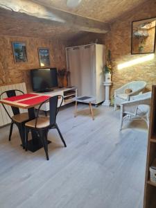 a living room with a table and chairs and a refrigerator at Chez Marie in Le Pallet