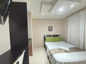 a small bedroom with a bed and a television at Hotel La Leyenda Vallenata in Valledupar
