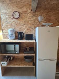 a kitchen with a white refrigerator and a clock at Chez Marie in Le Pallet