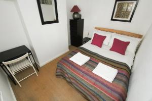 a bedroom with a large bed with red pillows at Marine Gardens - Central - by Brighton Holiday Lets in Brighton & Hove