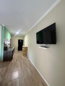 a living room with a flat screen tv on a wall at Apart Altos Del Pilar in Pilar