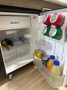 an open refrigerator filled with bottles and drinks at Apart Altos Del Pilar in Pilar