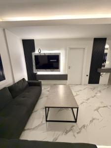 a living room with a couch and a table at Mirage Luxury Living in Nea Potidaea