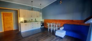 a kitchen with a blue couch and a table and chairs at Cabaña Guzman in Villarrica